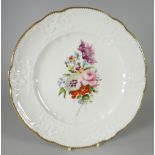 A NANTGARW PORCELAIN PLATE with lobed rim and having a moulded border with C-scrolls, flowers,