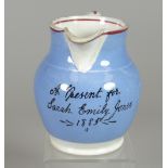 A LLANELLY POTTERY JUG 'A PRESENT FOR SARAH EMILY JONES 1885' with blue ground and red trim, 11cms