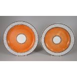 A PAIR OF SWANSEA POTTERY PLATES OF PLAIN FORM having a wide orange ground inner border, centred