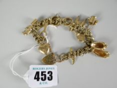 9ct gold charm bracelet with heart-shaped padlock and various charms to include donkey, bellows,