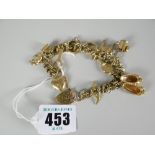 9ct gold charm bracelet with heart-shaped padlock and various charms to include donkey, bellows,