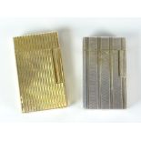 Two S T Dupont gas cigarette lighters - a machine turned white metal example and a ribbed yellow