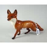 A Beswick standing fox with head peering to his left and brush extended, 24cms long Condition