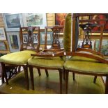 A set of four Edwardian inlaid mahogany and carved back bedroom chairs with stuff-over cushioned