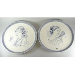 A pair of early twentieth century Wedgwood pottery chargers decorated with portraits of ladies in