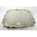 Large solid silver square tray or salver having pie crust edge, raised on four scroll feet,