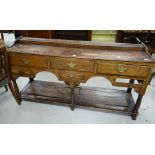 A nineteenth century oak Welsh dresser base having a configuration of three short drawers, a