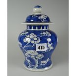 A Chinese pottery baluster vase and cover decorated in blue and white Prunus, 19cms high Condition