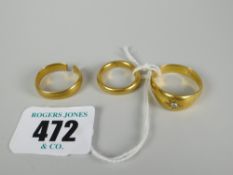 Three 22ct yellow gold rings comprising two band rings (one damaged) and another with small
