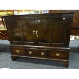 A nineteenth century dark oak mule chest with a base of three drawers, the facade converted to