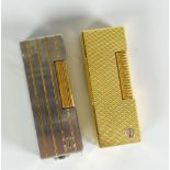 Two Dunhill cigarette lighters - a white metal example with gold stripes and a machine turned yellow