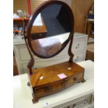 A good antique toilet mirror of oval form with bow-front base having two drawers on bracket feet,