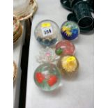 Five decorative glass paperweights and an ornamental flower