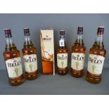 Four 1 litre bottles of Bells Blended Whisky, a boxed 70cl bottle of Bells Whisky and another 70cl