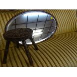 Mahogany bevelled oval wall mirror and a carved top milking stool