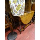 Oak drop leaf barley twist gate leg table and a turned column standard lamp with shade