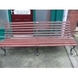 Wooden slatted garden bench with metal scrolled supports