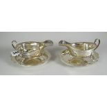 A pair of Elizabeth II silver sauce-boats on stands with matching garland decoration, on three pad-