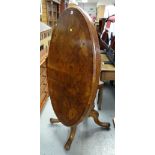An antique inlaid burr walnut oval tilting breakfast table on carved spider supports, top 85cms wide