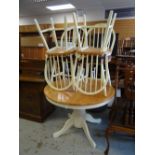 A good modern circular / oval extending dining table on cream supports and with four matching hoop-