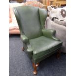 A vintage studded green leather wingback armchair Condition reports provided on request by email for