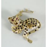 A 9ct yellow gold gem set leopard brooch, the body set with tiny sapphires and the eyes ruby set,