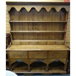 A good reproduction Welsh-type dresser having a planked floor-level platform base, three deep