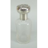A textured glass dressing table bottle with silver screw lid and collar having repousse decoration