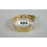 A 9ct yellow gold bangle in the form of a belt with buckle, 10 grams Condition reports provided on