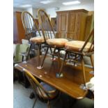 A mid-century Ercol dark wood refectory-type dining table and four matching hoop back chairs