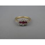 A NINE CARAT GOLD RUBY & DIAMOND CLUSTER DRESS RING, having three oblong cut centre rubies with