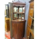 A VICTORIAN MAHOGANY BOW FRONT STANDING CORNER CUPBOARD with mirrored top structure and curved shelf