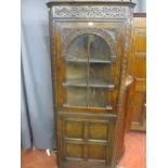 A GOOD FLOORSTANDING REPRODUCTION OAK CORNER CABINET in the antique style, well coloured with carved