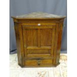 AN ANTIQUE OAK CORNER CUPBOARD, wall hanging with panel front door and lower drawer, 92.5 cms