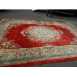 A WASHED CHINESE CARPET, red ground with floral pattern, 3.3 x 5.3 metres