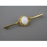 A NINE CARAT GOLD BAR BROOCH with oval centre opal in a twist mount, 1 x 0.8 cms, 3.4 grms gross