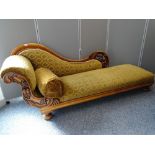 A WELL CARVED VICTORIAN CHAISE LONGUE having fruit and vine detail on substantial bun feet, 81.5 cms
