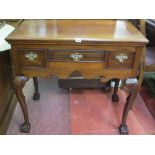 A REPRODUCTION THREE DRAWER LOWBOY on cabriole shell supports with ball and claw feet