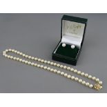 A SINGLE STRAND CULTURED PEARL NECKLACE with nine carat gold clasp together with a pair of