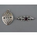 AN OVAL SILVER CELTIC STYLE PENDANT, 4 cms long, 7 grms and a white metal thistle brooch with oval