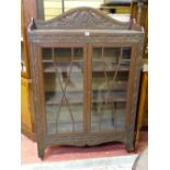 A VINTAGE CARVED OAK BOOKCASE having three quarter top rail over twin eight pane astragal glazed