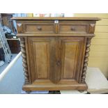 A CONTINENTAL OAK SIDE CUPBOARD having two upper drawers and two lower cupboard doors flanked by