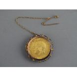 A 1911 GEORGE V GOLD SOVEREIGN in a yellow metal mount with pin