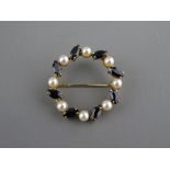 A NINE CARAT GOLD WREATH SHAPED SAPPHIRE & PEARL BROOCH, 4.5 grms gross