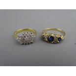 A NINE CARAT GOLD DIAMOND & SAPPHIRE DRESS RING having a centre round cut sapphire with two flanking