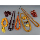 SIX AMBER COLOUR NECKLACES, a quantity of loose beads and three brooches, all untested, various