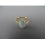 A POSSIBLY EIGHTEEN CARAT GOLD OPAL DRESS RING, 1.2 x 0.8 cms, 2.5 grms gross, size 'N/O'