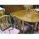 AN OVAL MAHOGANY WIND-OUT DINING TABLE with one leaf, on cabriole and ball and claw supports and six