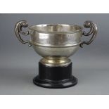 A CIRCULAR SILVER PEDESTAL SPORTING TROPHY with double scrolled handles, on a plinth, 12 troy ozs,