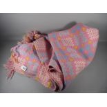 A WELSH WOOLLEN BLANKET, pink, blue and yellow ground with repeating block pattern (repaired patch),